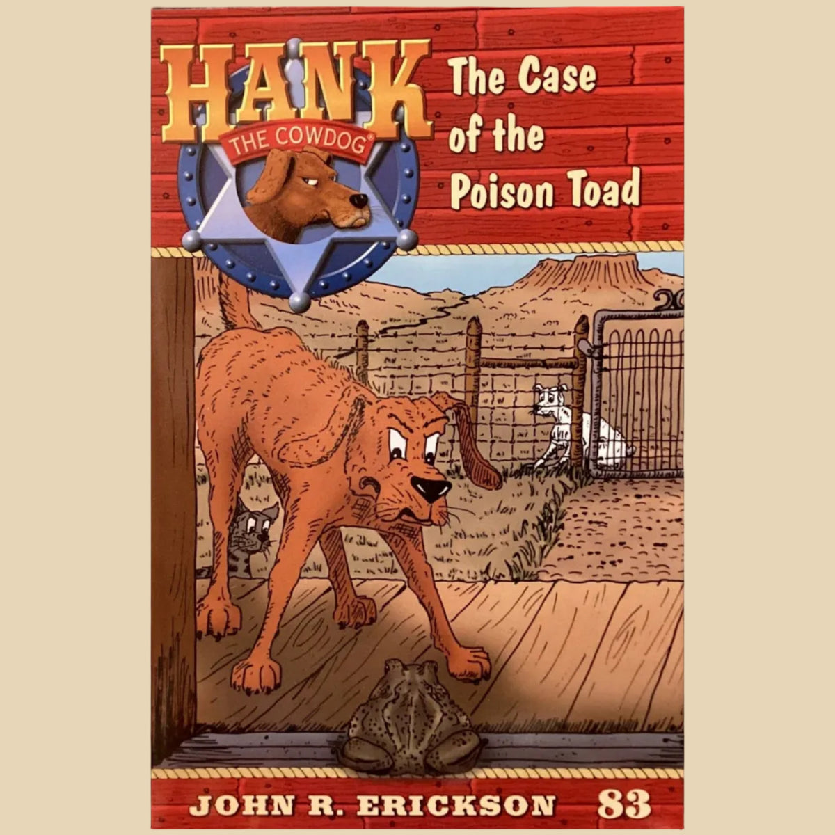 Book titled 'Hank the Cowdog: The Case of the Poison Toad' by John R. Erickson on a gray surface.