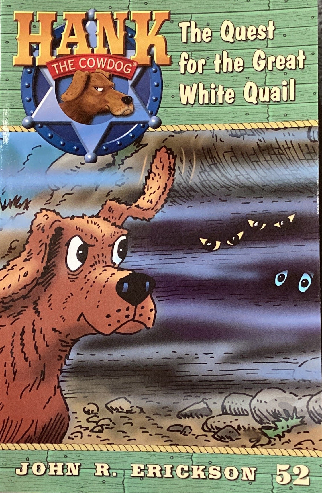 Children's book titled 'Hank the Cowdog: The Quest for the Great White Quail' on a shelf.