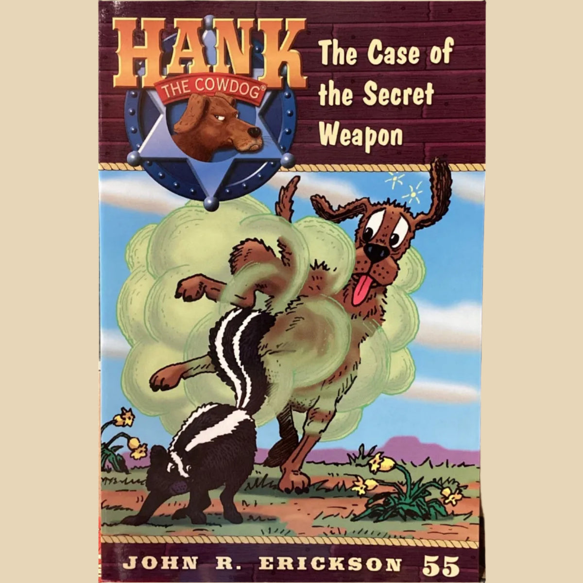 Book titled 'Hank the Cowdog: The Case of the Secret Weapon' by John R. Erickson on a surface.