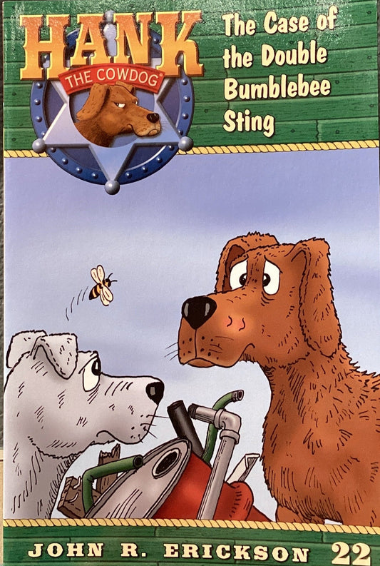 Book titled 'Hank the Cowdog: The Case of the Double Bumblebee Sting' by John R. Erickson on a surface with a gray wall background.