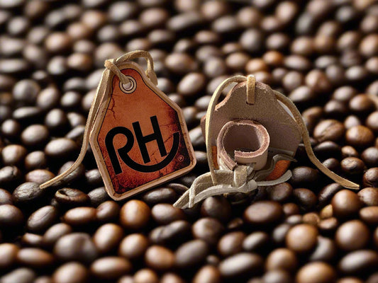 Pair of beige leather booties with a brown tag featuring 'RH' on a light gray background