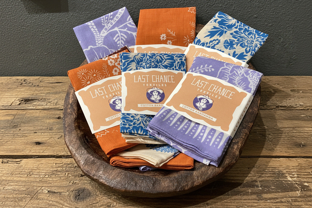 Collection of folded towels with 'Last Chance' branding in a wooden bowl.