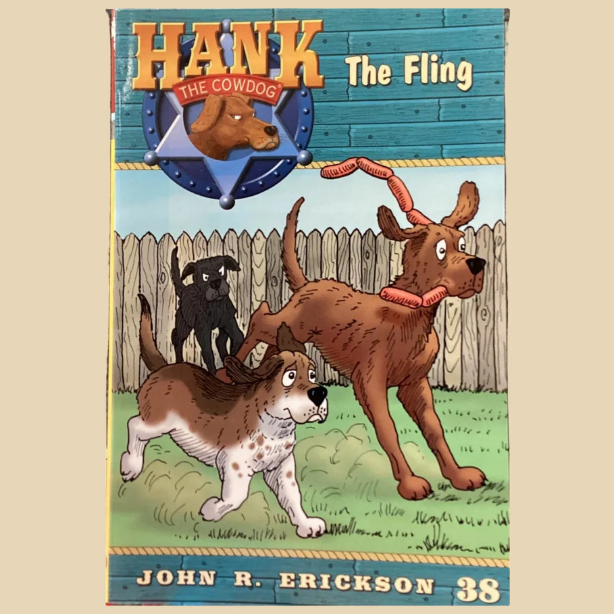 Book titled 'Hank the Cowdog: The Fling' by John R. Erickson on a dark surface.