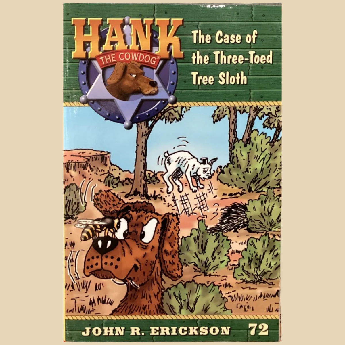 Book titled 'Hank the Condoog: The Case of the Three-Toed Tree Sloth' by John R. Erickson on a gray surface.
