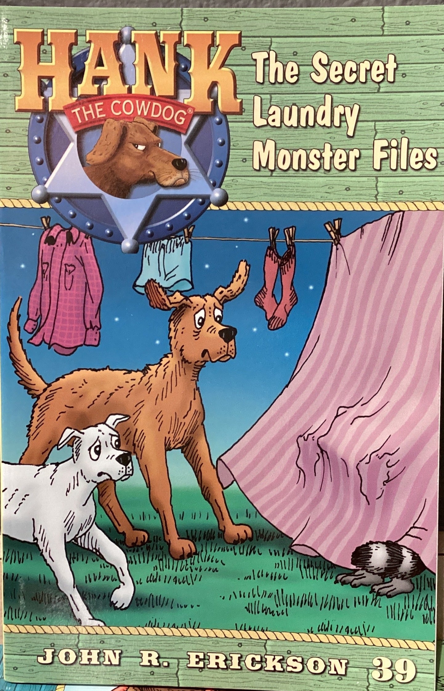 Book titled 'Hank the Cowdog: The Secret Laundry Monster Files' by John R. Erickson on a gray surface.