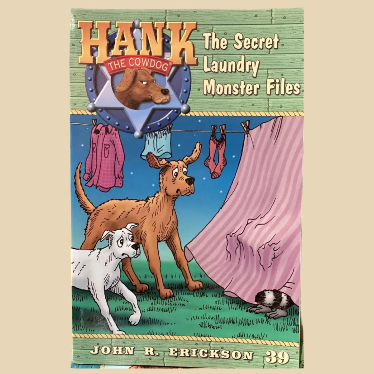 Book titled 'Hank the Cowdog: The Secret Laundry Monster Files' by John R. Erickson on a gray surface.