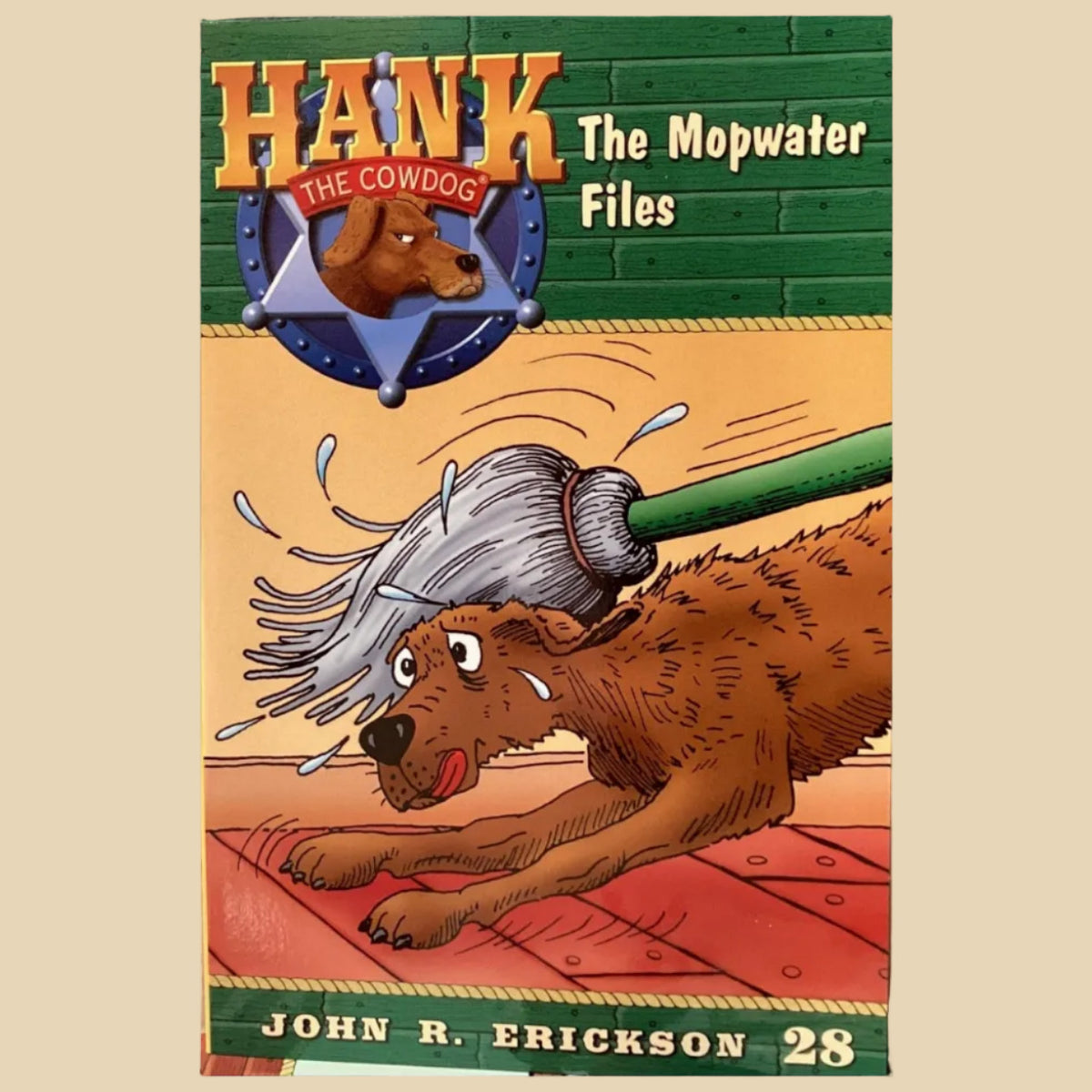 Book titled 'Hank the Cowdog: The Mopwater Files' by John R. Erickson on a gray surface.