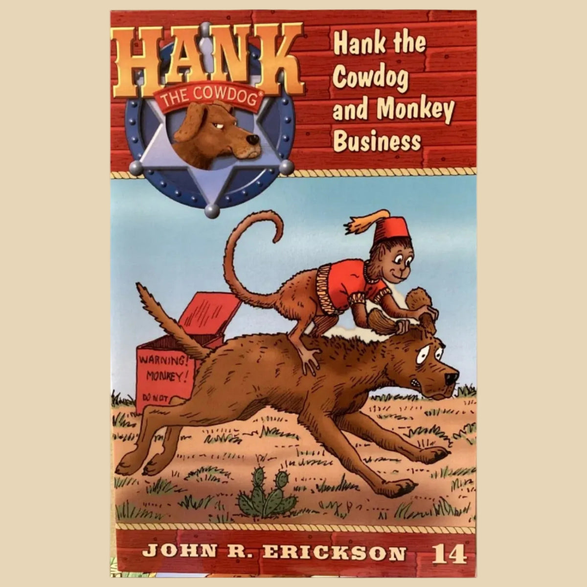 Book cover of 'Hank the Cowdog and Monkey Business' by John R. Erickson on a textured surface.