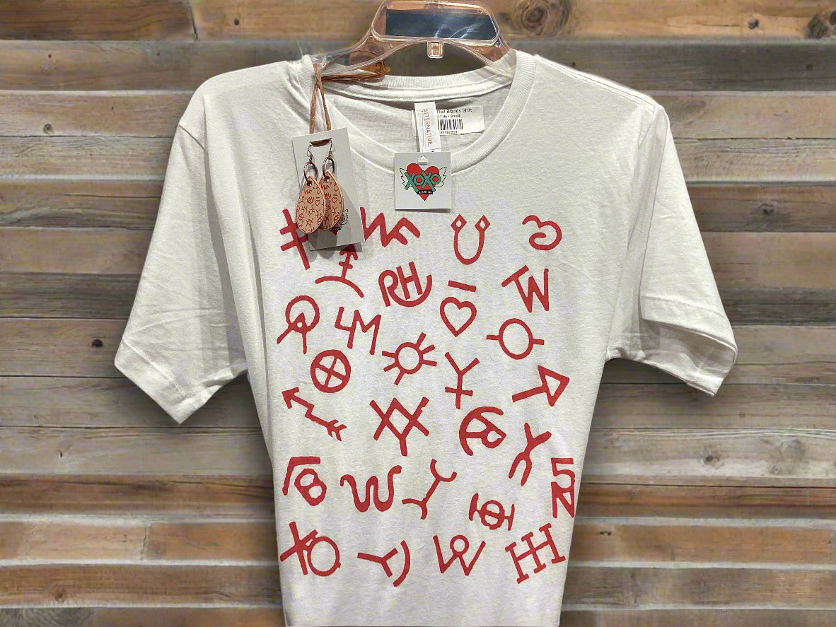 White t-shirt with red symbols and text on a hanger against a wooden panel background
