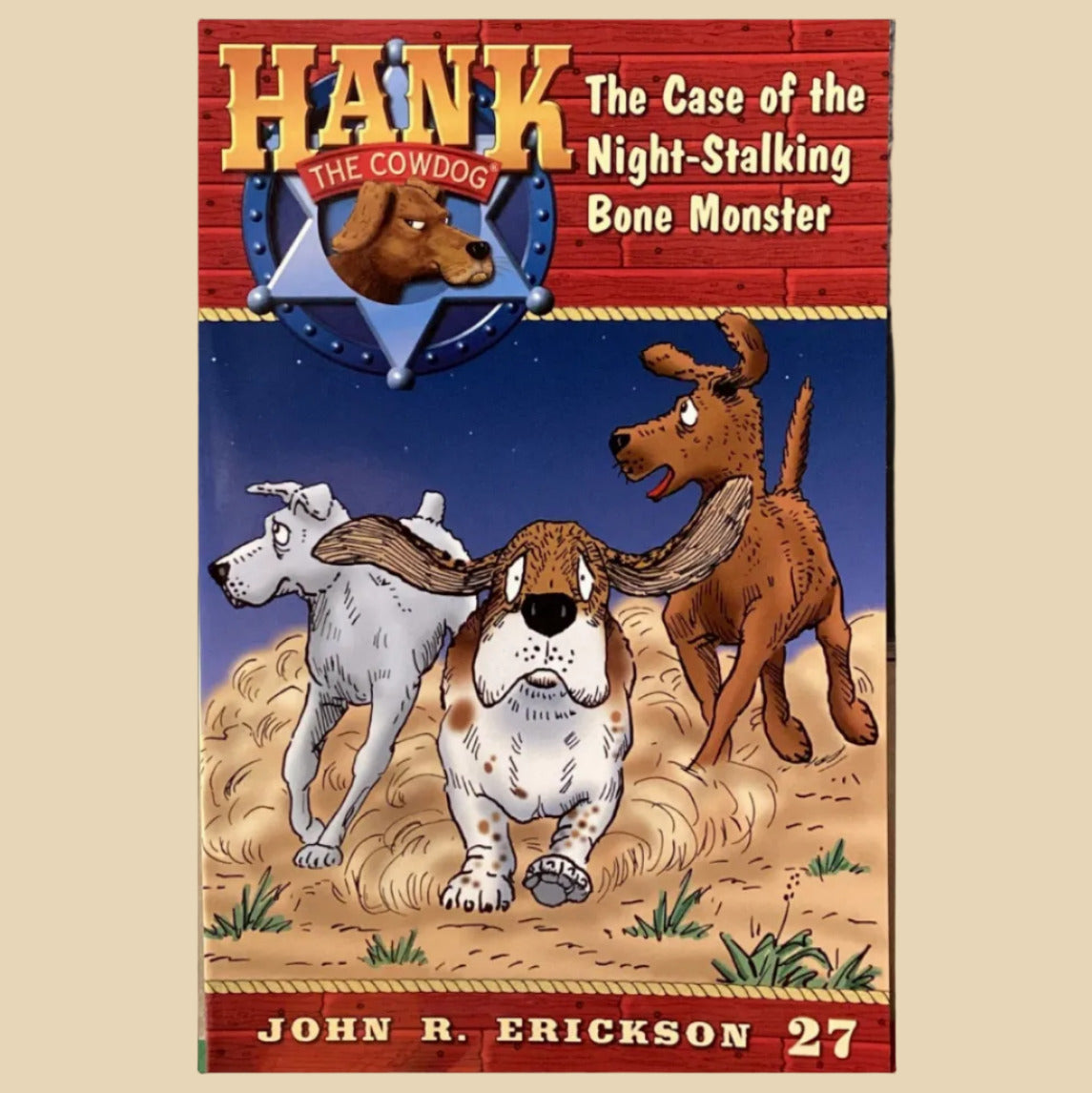 Book titled 'Hank the Cowdog: The Case of the Night-Stalking Bone Monster' by John R. Erickson on a shelf.