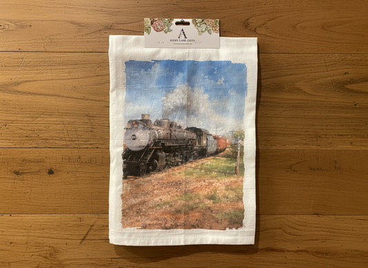 Tea towel with a train design hanging on a gray wall