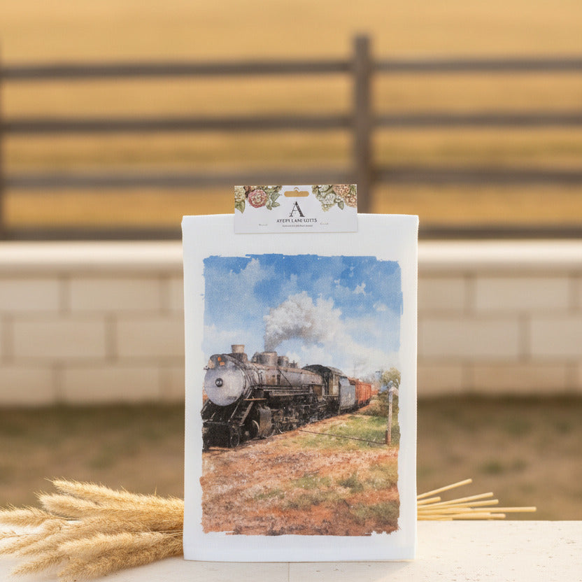 Tea towel with a train design hanging on a gray wall