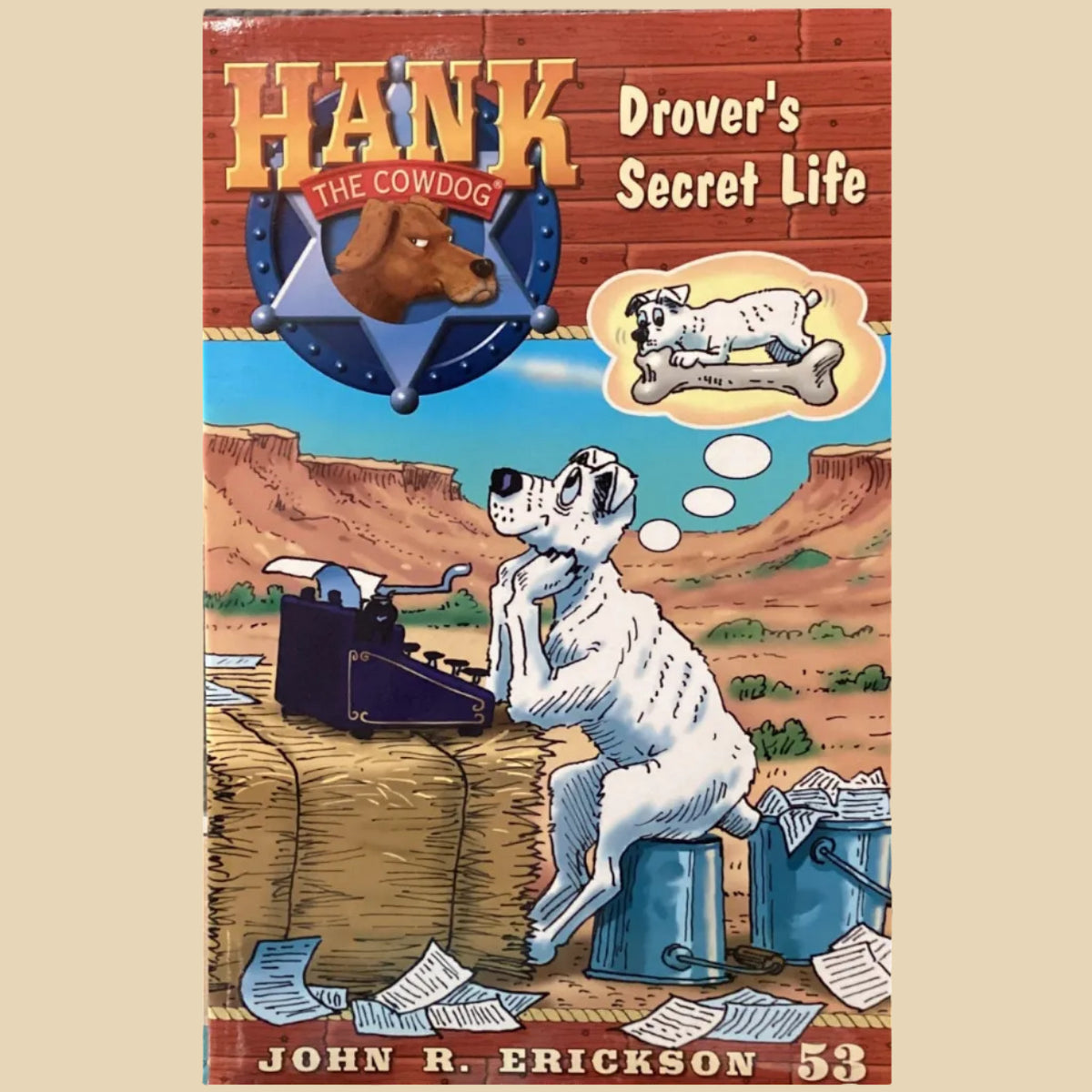 Book titled 'Hank the Cowdog: Drover's Secret Life' by John R. Erickson on a gray surface.