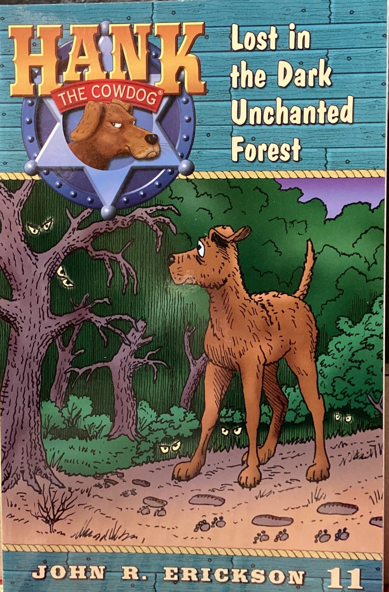 Book titled 'Hank the Cowdog: Lost in the Dark Unchanted Forest' by John R. Erickson on a gray surface.