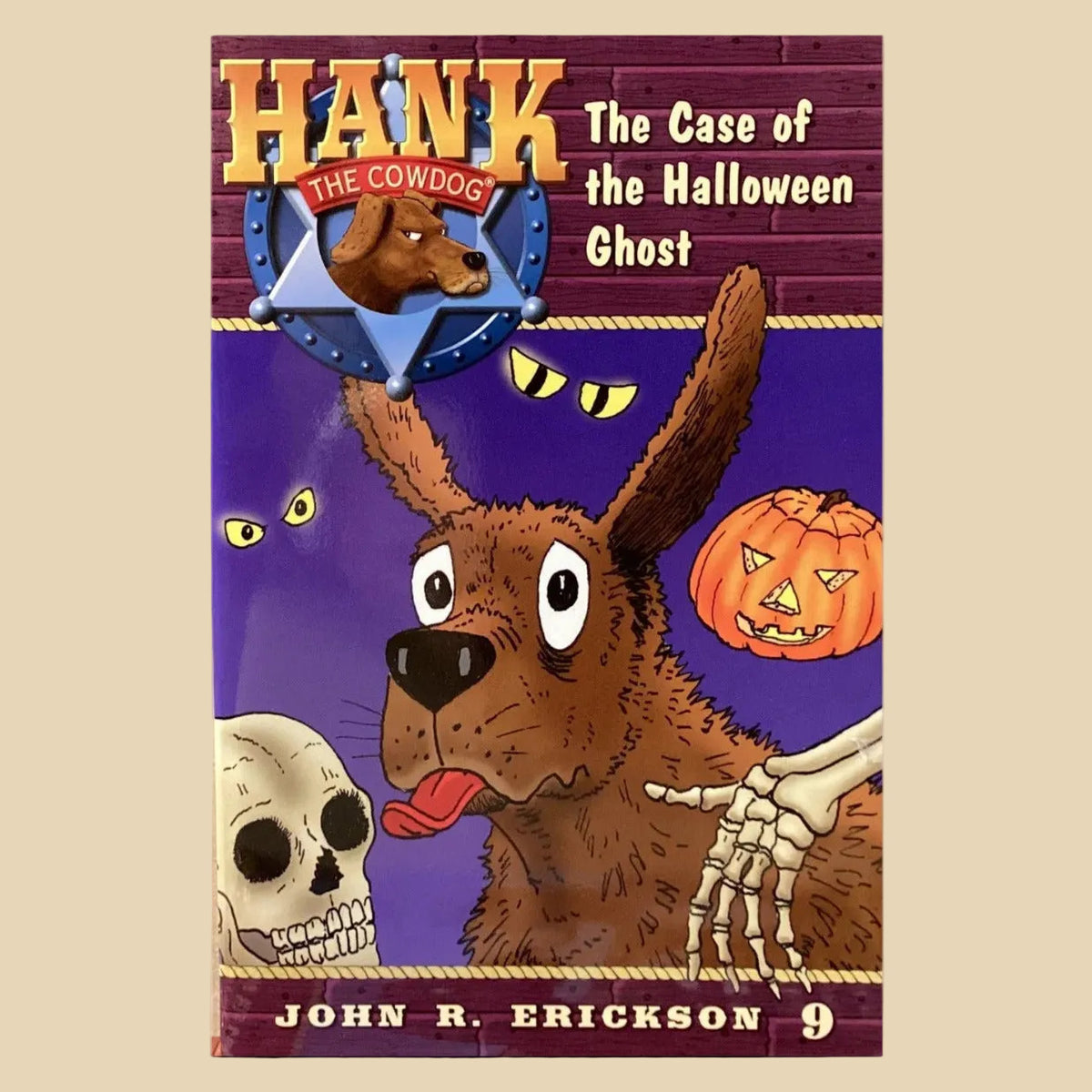 Book titled 'Hank the Cowdog: The Case of the Halloween Ghost' by John R. Erickson on a surface with a gray wall background.