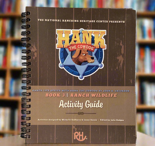 Spiral-bound book titled 'Hank the Cowboy Ranch Wildlife Activity Guide' on a gray surface.