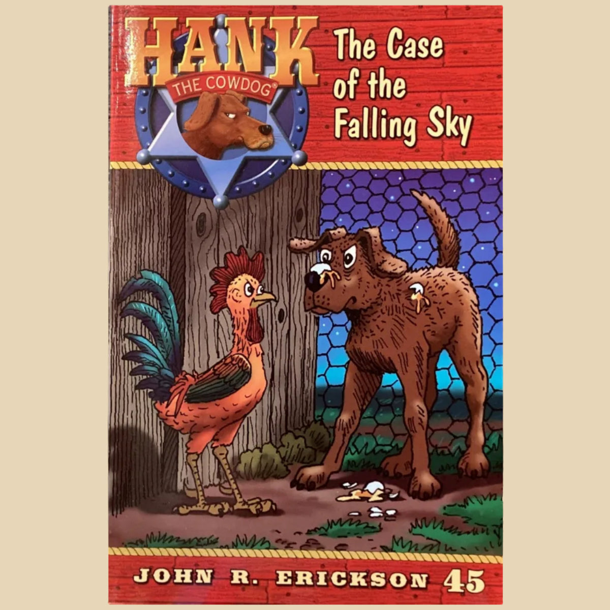 Book titled 'Hank the Cowdog: The Case of the Falling Sky' by John R. Erickson on a surface with a gray wall background.