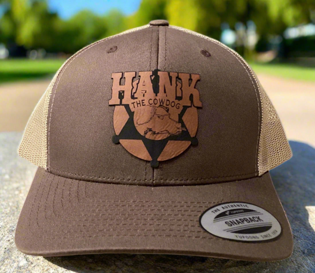 Brown and beige cap with a logo on a table against a gray wall.