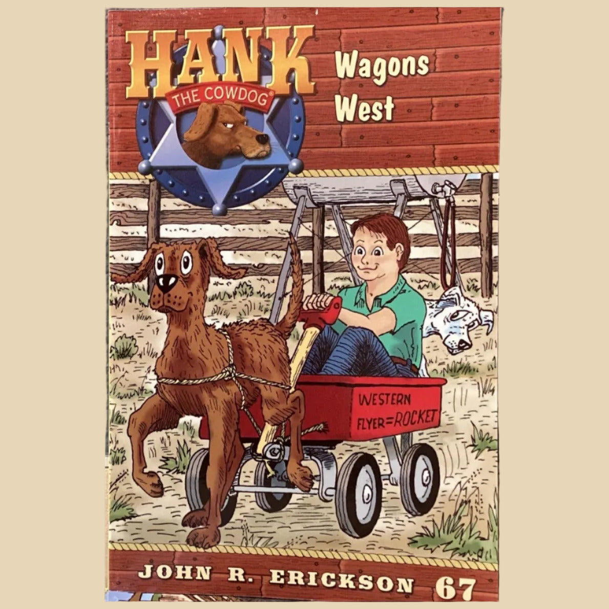 Book titled 'Hank Wagon West' by John R. Erickson on a table with a dark gray wall background.