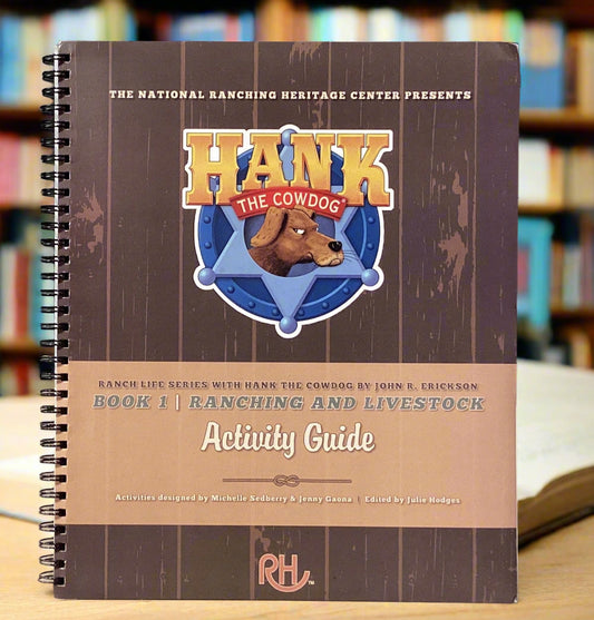 Activity guide book titled 'Hank the Cowdog' on a surface with a gray wall background
