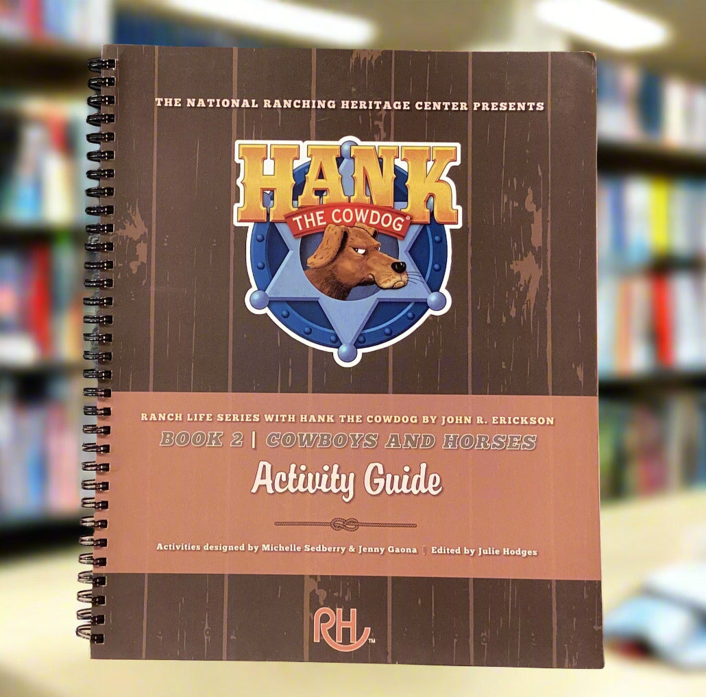 Notebook titled 'Hank the Cowdog Activity Guide' on a surface with a gray wall background