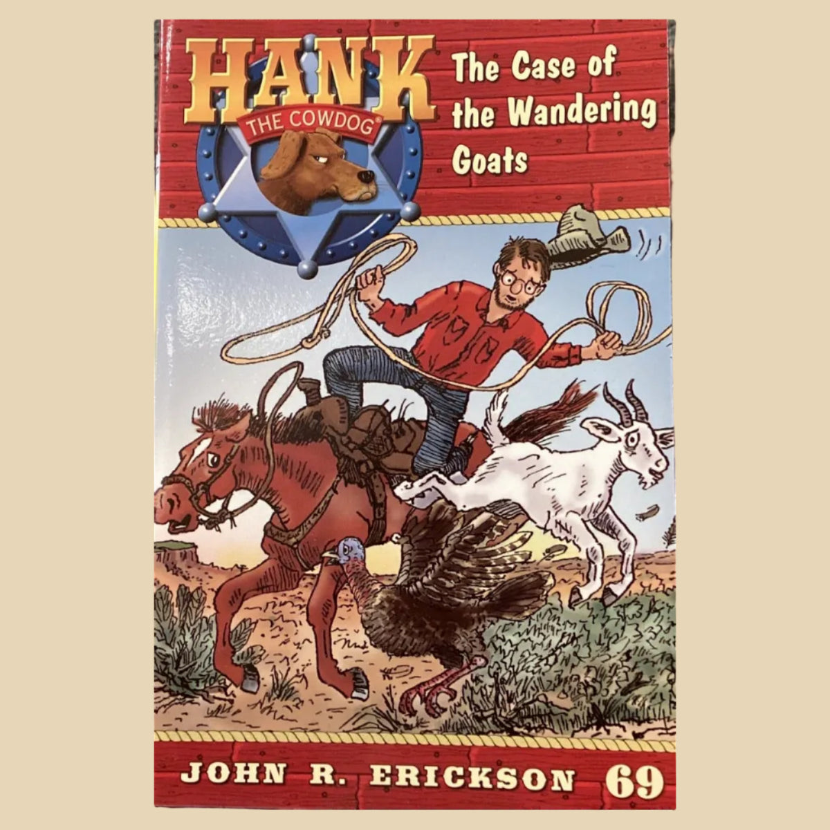 Book titled 'Hank the Cowdog: The Case of the Wandering Goats' by John R. Erickson on a dark surface.