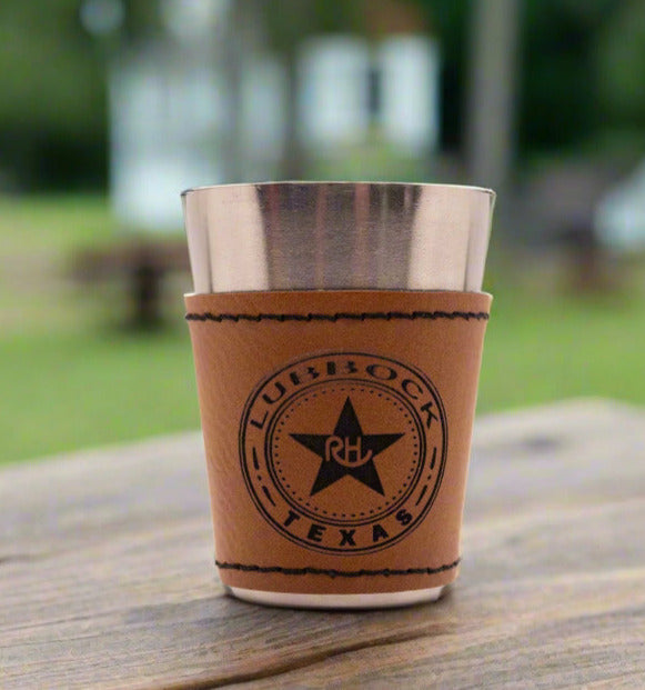 Leather cup with metal liner on a wooden surface outdoors