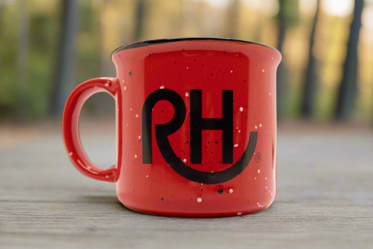 A red ceramic mug with the letters 'RH' in black.