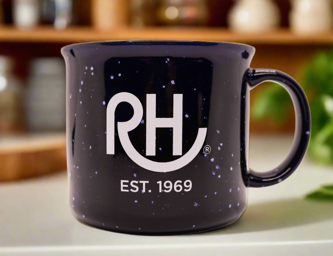 A navy blue ceramic mug with white speckles and the 'RH' logo along with the text 'EST. 1969' printed in white on the side.