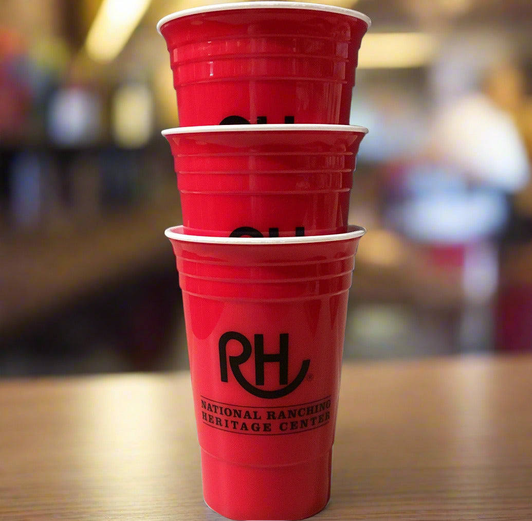 Stack of red plastic cups with a logo on a gray wall background