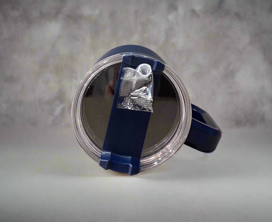 Blue watch in a clear display case on a white surface with a gray wall background