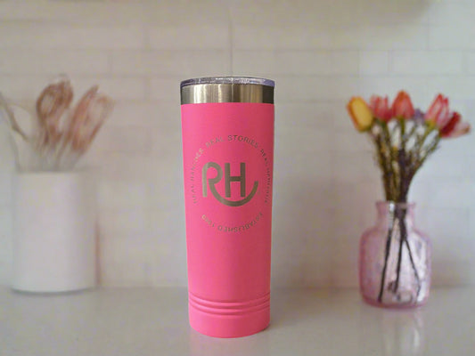 Pink tumbler with a logo on a gray surface