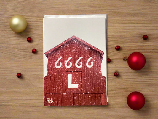 Card with a red barn design and '6666 L' text against a gray wall.