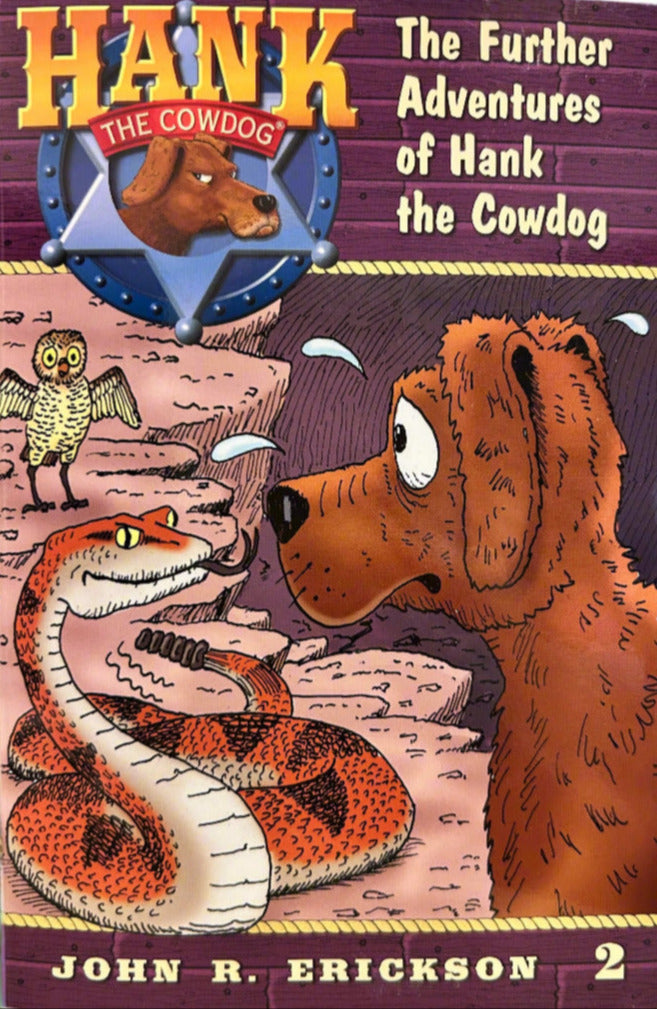 Book cover of 'The Further Adventures of Hank the Cowdog' by John R. Erickson on a wooden surface.