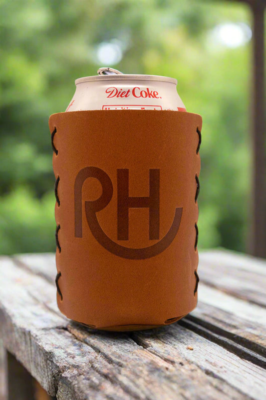 A brown leather koozie with the initials 'RH' embossed on the front, holding a can of Diet Coke.