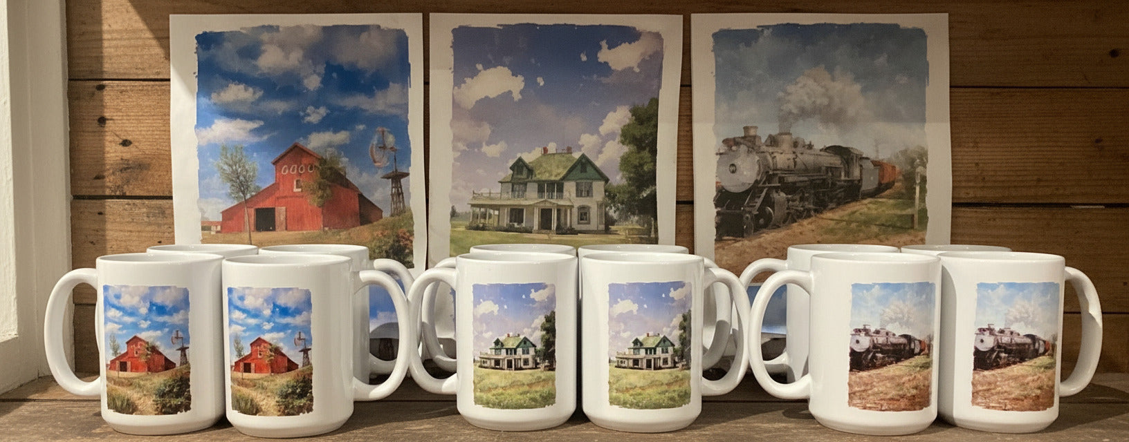 Set of mugs with scenic prints on a wooden shelf