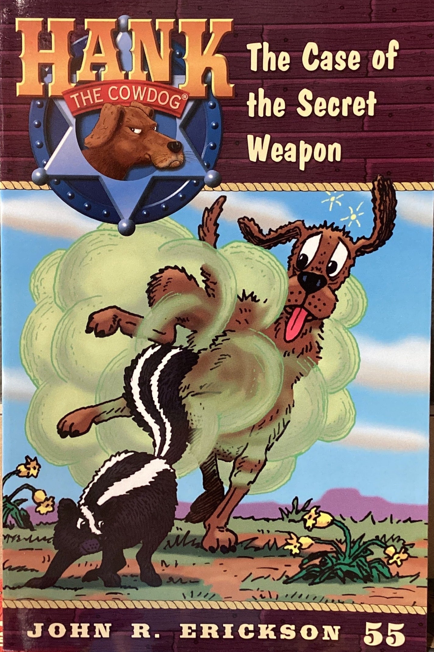 Book titled 'Hank the Cowdog: The Case of the Secret Weapon' by John R. Erickson on a surface.