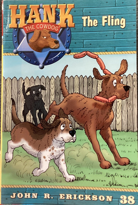 Book titled 'Hank the Cowdog: The Fling' by John R. Erickson on a dark surface.