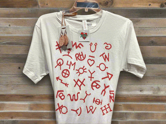 White t-shirt with red symbols and text on a hanger against a wooden panel background