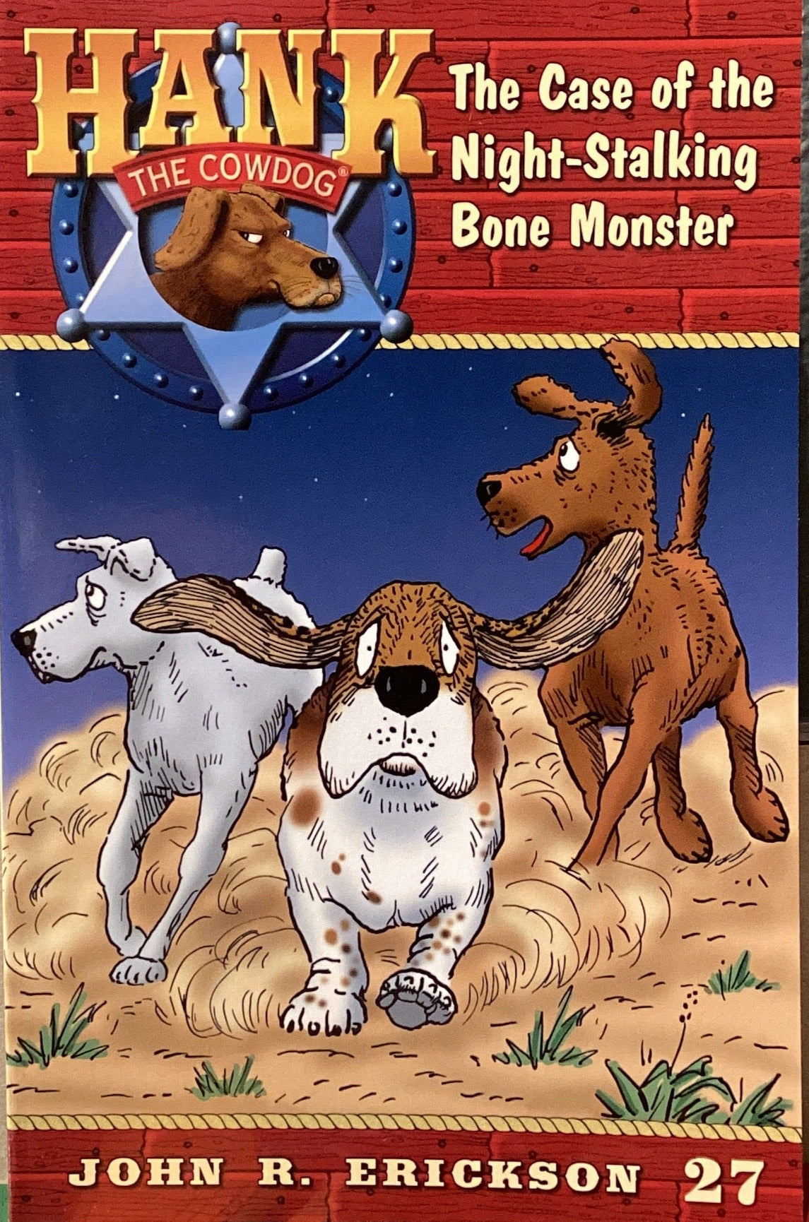 Book titled 'Hank the Cowdog: The Case of the Night-Stalking Bone Monster' by John R. Erickson on a shelf.