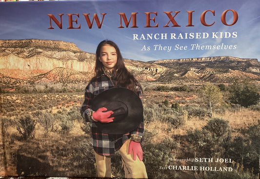 Book titled 'New Mexico Ranch Raised Kids' on a surface with a bookshelf background