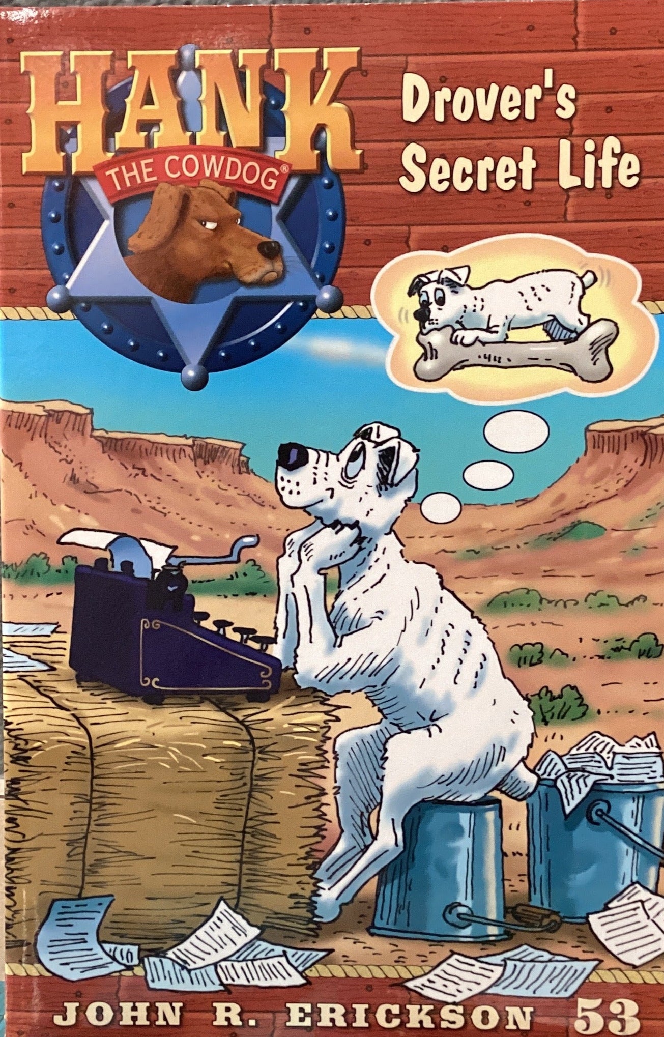 Book titled 'Hank the Cowdog: Drover's Secret Life' by John R. Erickson on a gray surface.