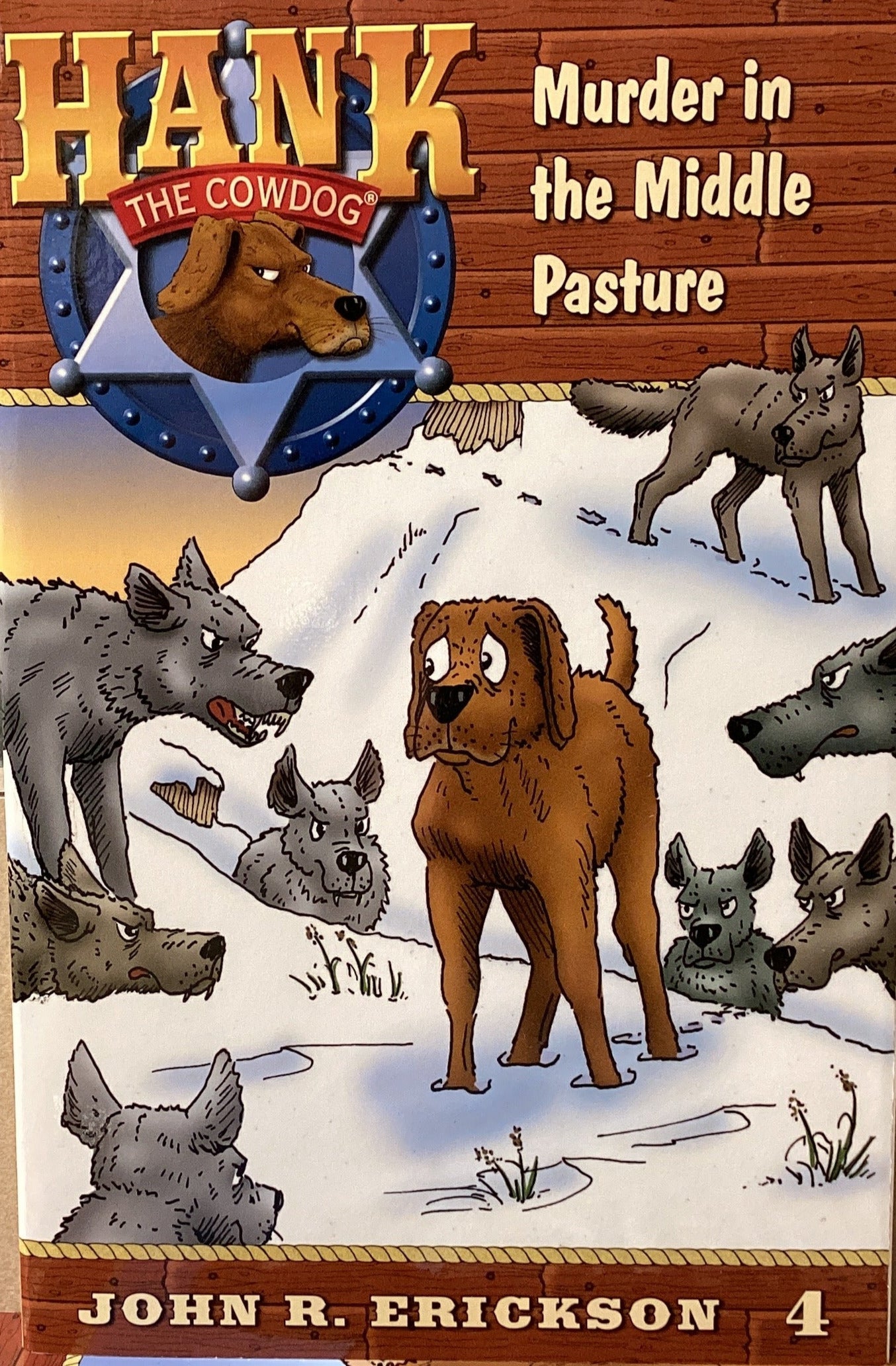 Book titled 'Hank the Cowdog: Murder in the Middle Pasture' by John R. Erickson on a gray surface.