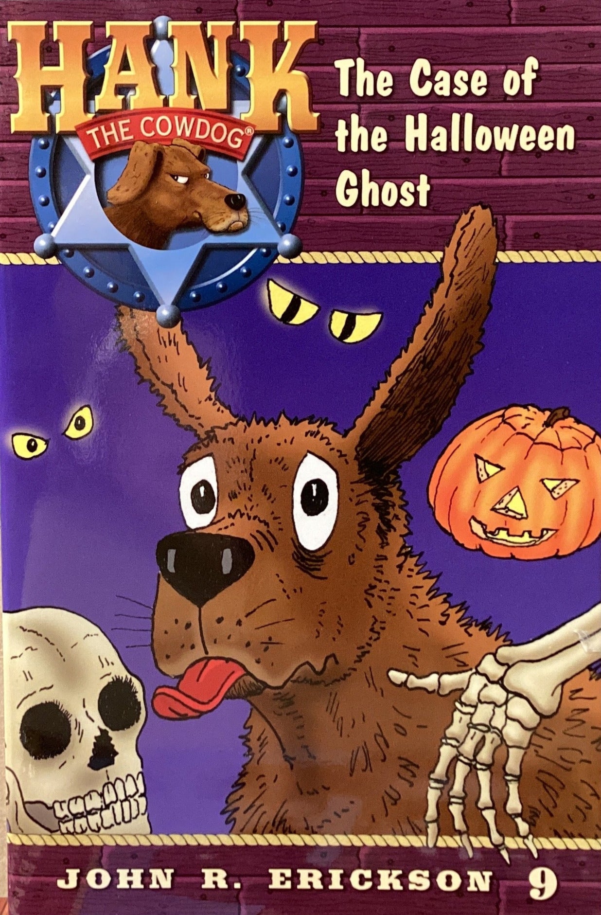 Book titled 'Hank the Cowdog: The Case of the Halloween Ghost' by John R. Erickson on a surface with a gray wall background.