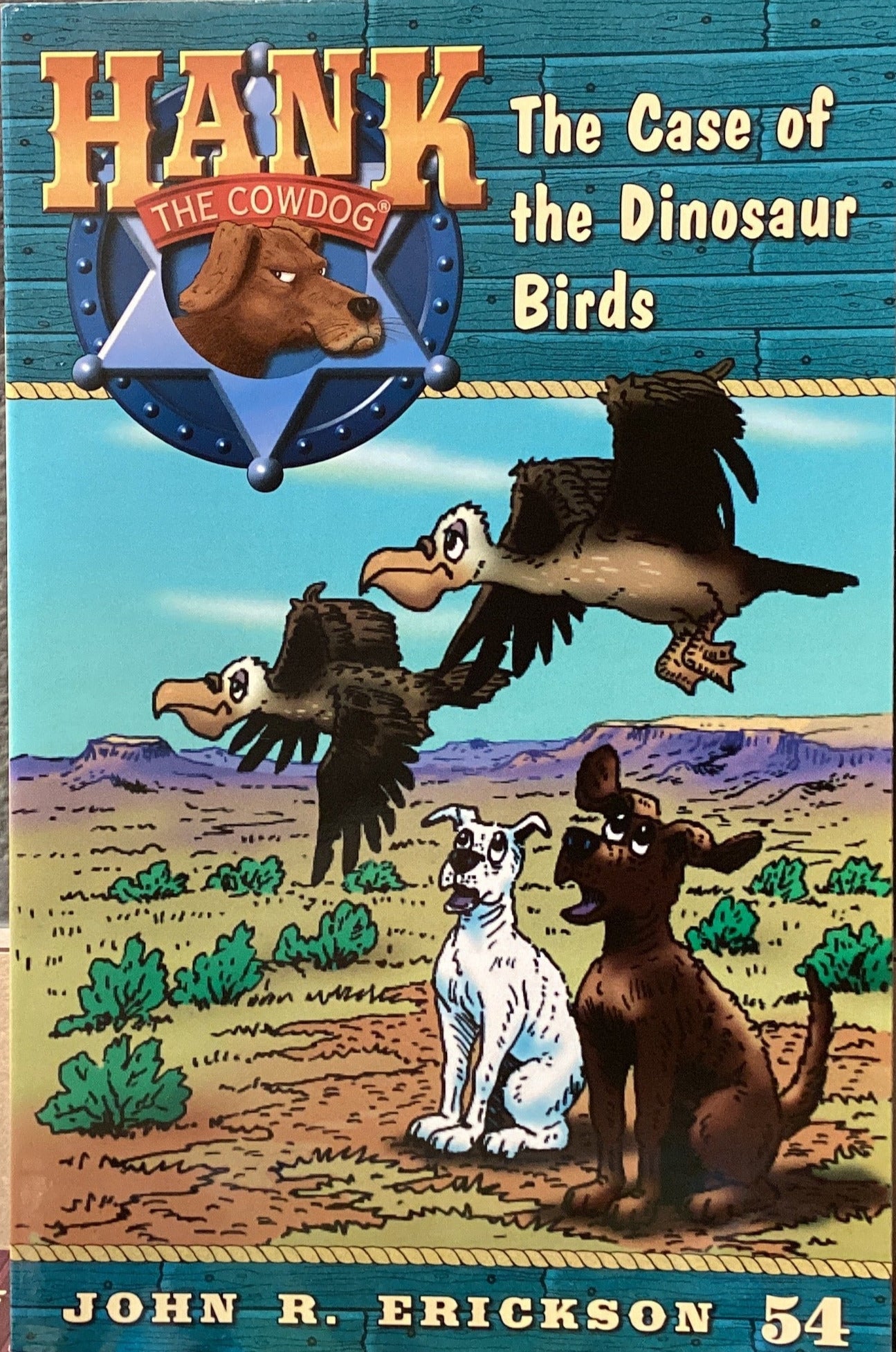 Book titled 'Hank the Cowdog: The Case of the Dinosaur Birds' by John R. Erickson on a shelf.