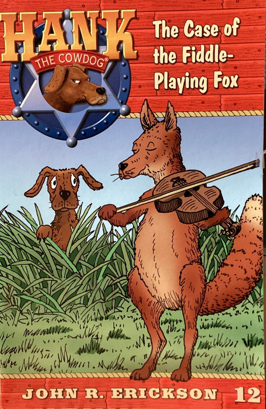 Book titled 'Hank the Cowdog: The Case of the Fiddle-Playing Fox' by John R. Erickson on a gray surface.