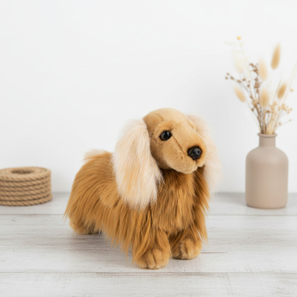 A plush dachshund dog toy with long golden-brown fur, cream-colored ears, and a black nose, isolated on a white background.