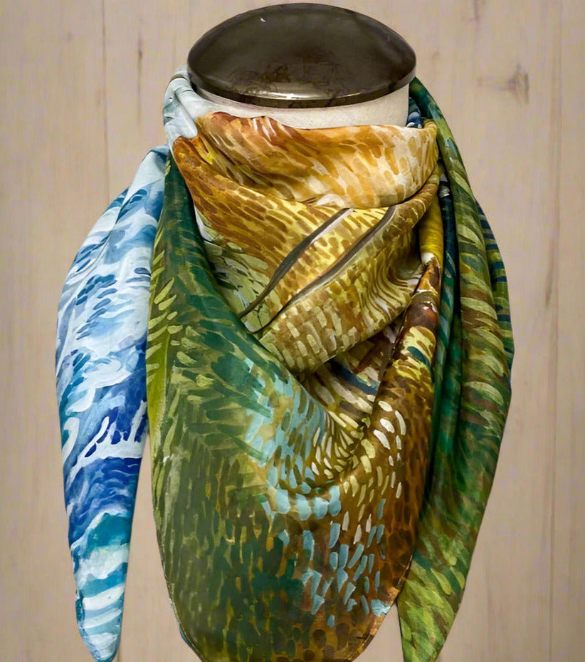 Colorful scarf with abstract patterns draped over a mannequin head on a white background