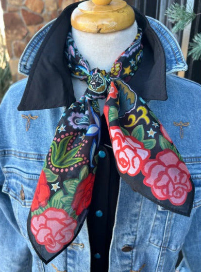 Mannequin wearing a colorful scarf with floral patterns on a white background