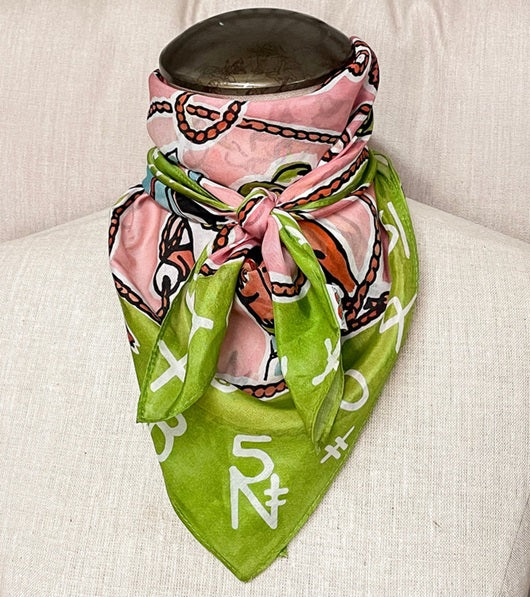 Green and pink patterned scarf draped over a pot on a beige surface